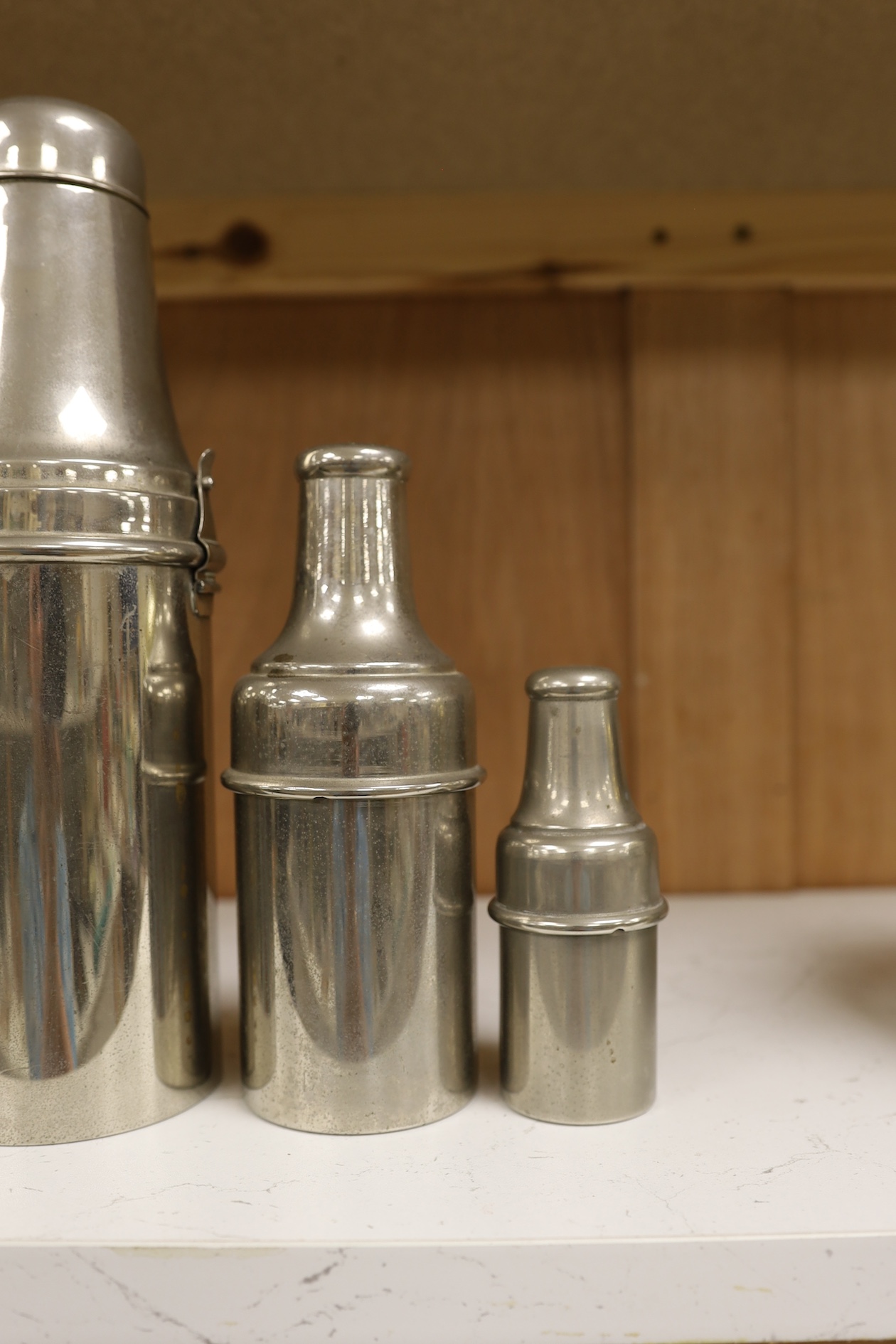 A 1920's chrome plated travelling cocktail flask set and two similar cased bottles, tallest 28.5cm high. Condition - fair